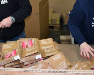 Werknemers zijn druk met het ompakken van boeken op de werkvloer.